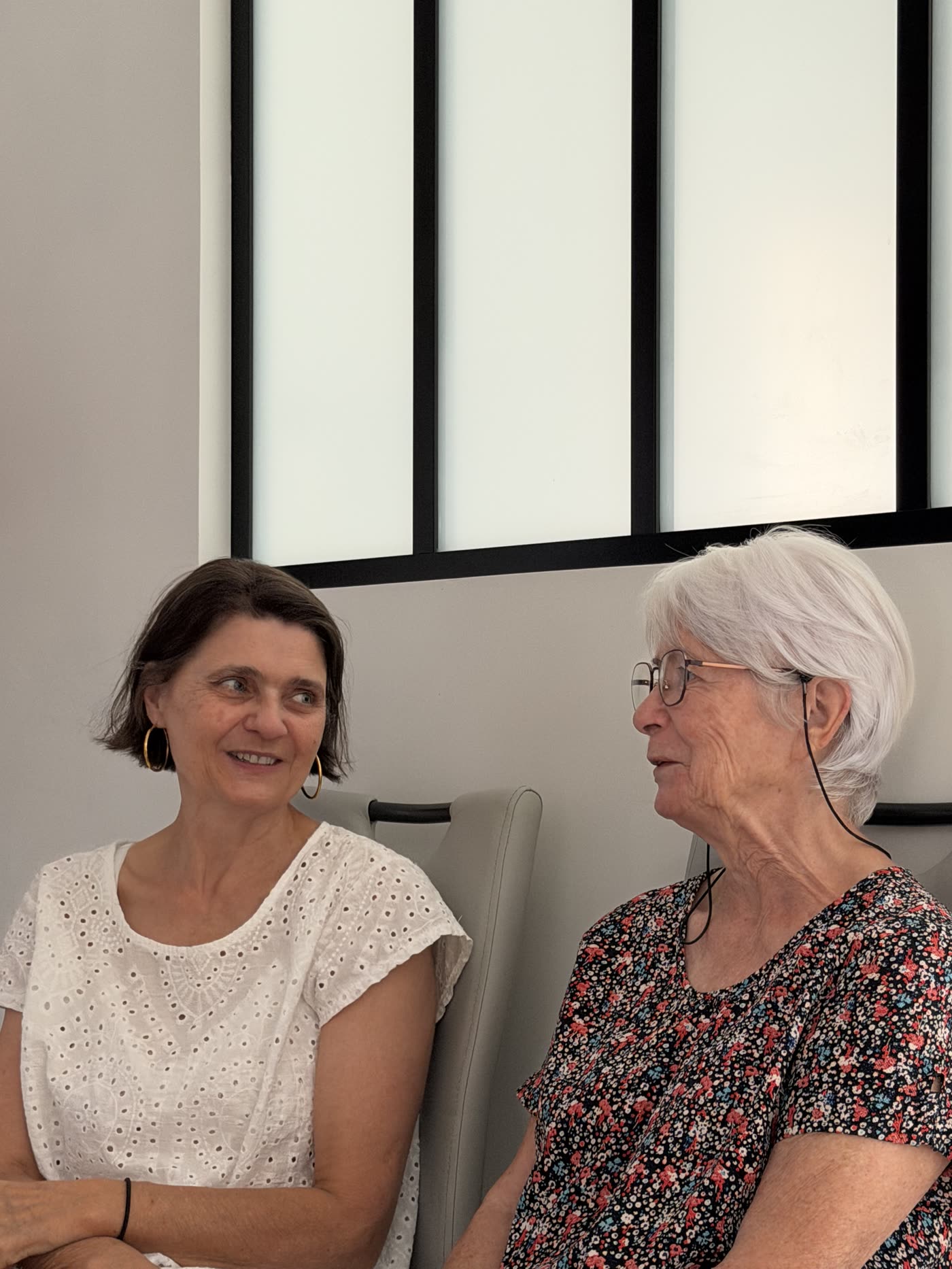 Une accompagnatrice et une personne âgée discutant calmement au salon